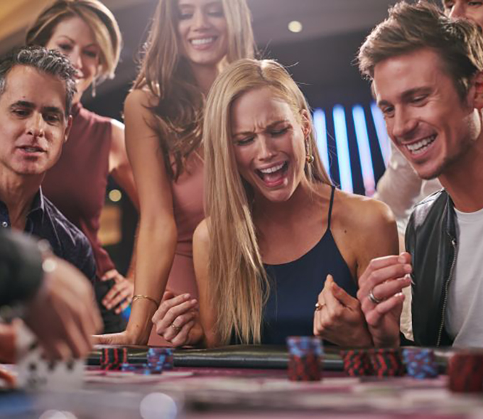 Group of People Playing Cards at a Table in Casino